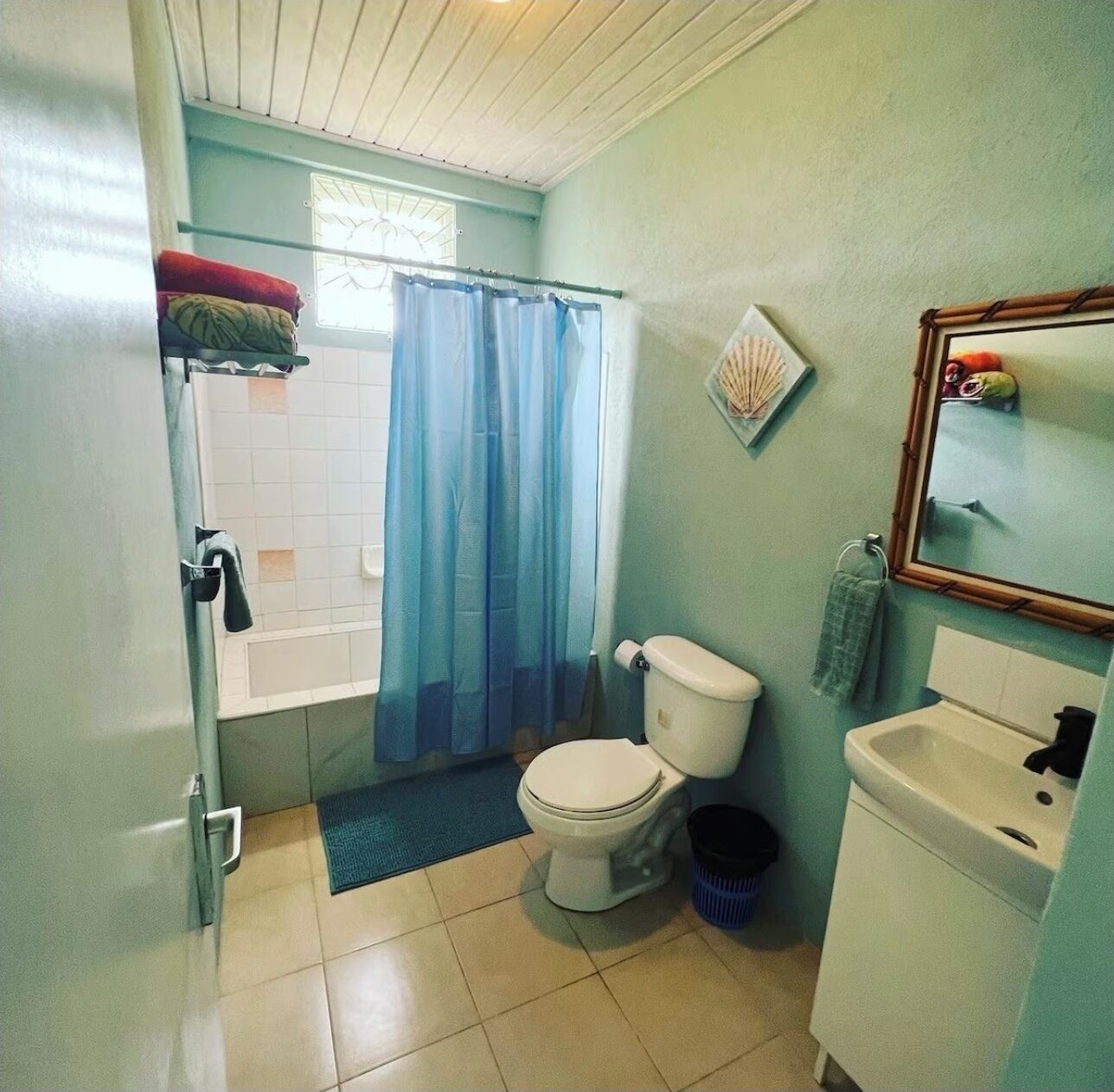 A bathroom with a toilet, sink, and shower area.