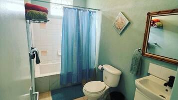 A bathroom with a toilet, sink, and shower area.