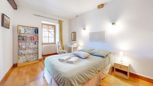 A bedroom with a large bed, a bookshelf, a desk, and a window. - 2 bedroom nice home in Volnay (Volnay)