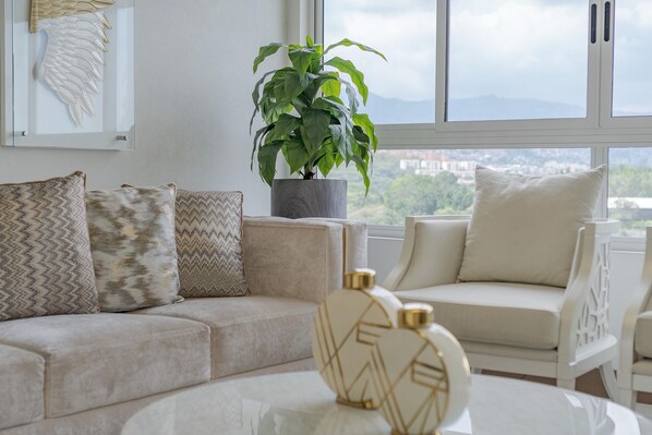 Relax in this stylish living room with a sofa, armchair, and city view.