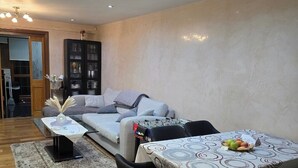 Un salon moderne comprenant un canapé, une table à manger avec des chaises et un meuble de rangement.