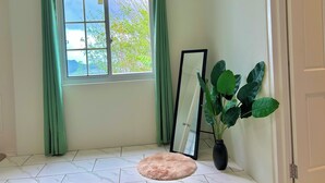 A room with a window, a mirror, a plant, and a door. - Hillside Escape- Private Pool & Breathtaking Sunset Over the Town (Bequia)