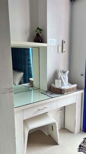 Ein modernes Badezimmer mit einem Glastischchen, einem Handtuchhalter und einer kleinen Pflanze.