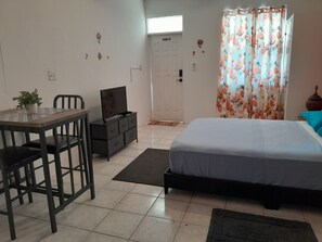 A bedroom with a bed, a desk with a chair, a television, and a potted plant. - Abigail’s Diamond near Nanny Cay 1 Bedroom (Tortola)