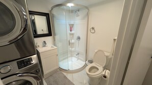 A compact bathroom with a glass-enclosed shower, a toilet, and a washing machine. - Cozy & Private Suite w/ Private Entrance & Parking (Richmond Hill)