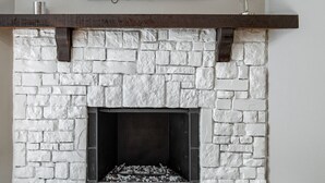 Una chimenea con frente de piedra y un televisor de pantalla plana montado encima.