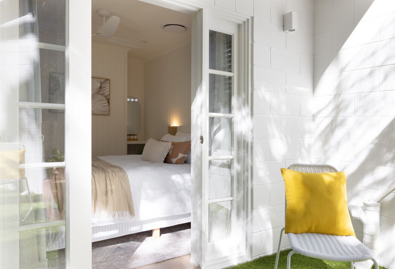 A bedroom with a bed, a nightstand, and a window.