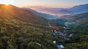 A mountainous landscape with a village nestled among the hills. - Lafite Apple B&B (Hangzhou)
