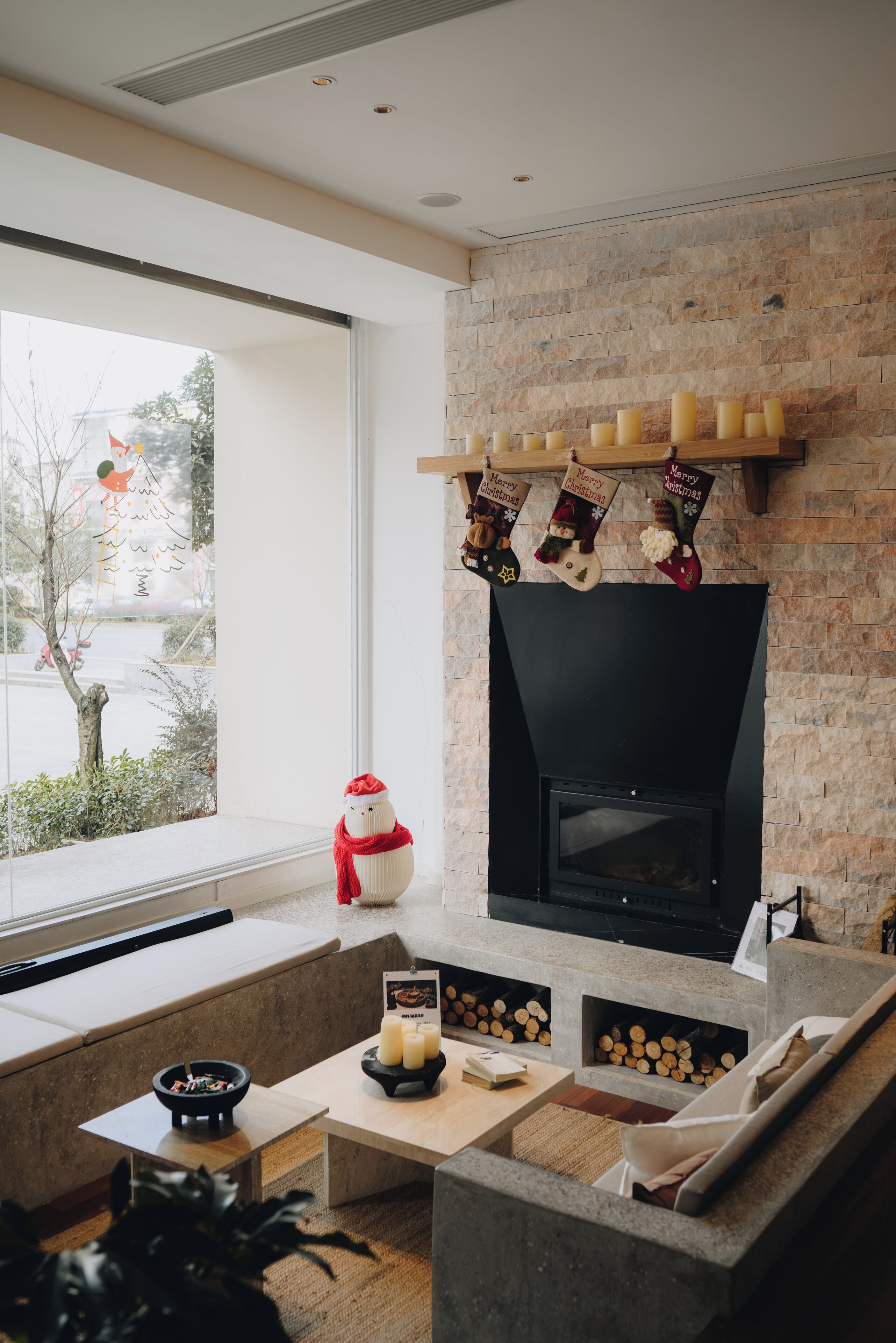 A modern living room with a fireplace, seating area, and a view of the outdoors.