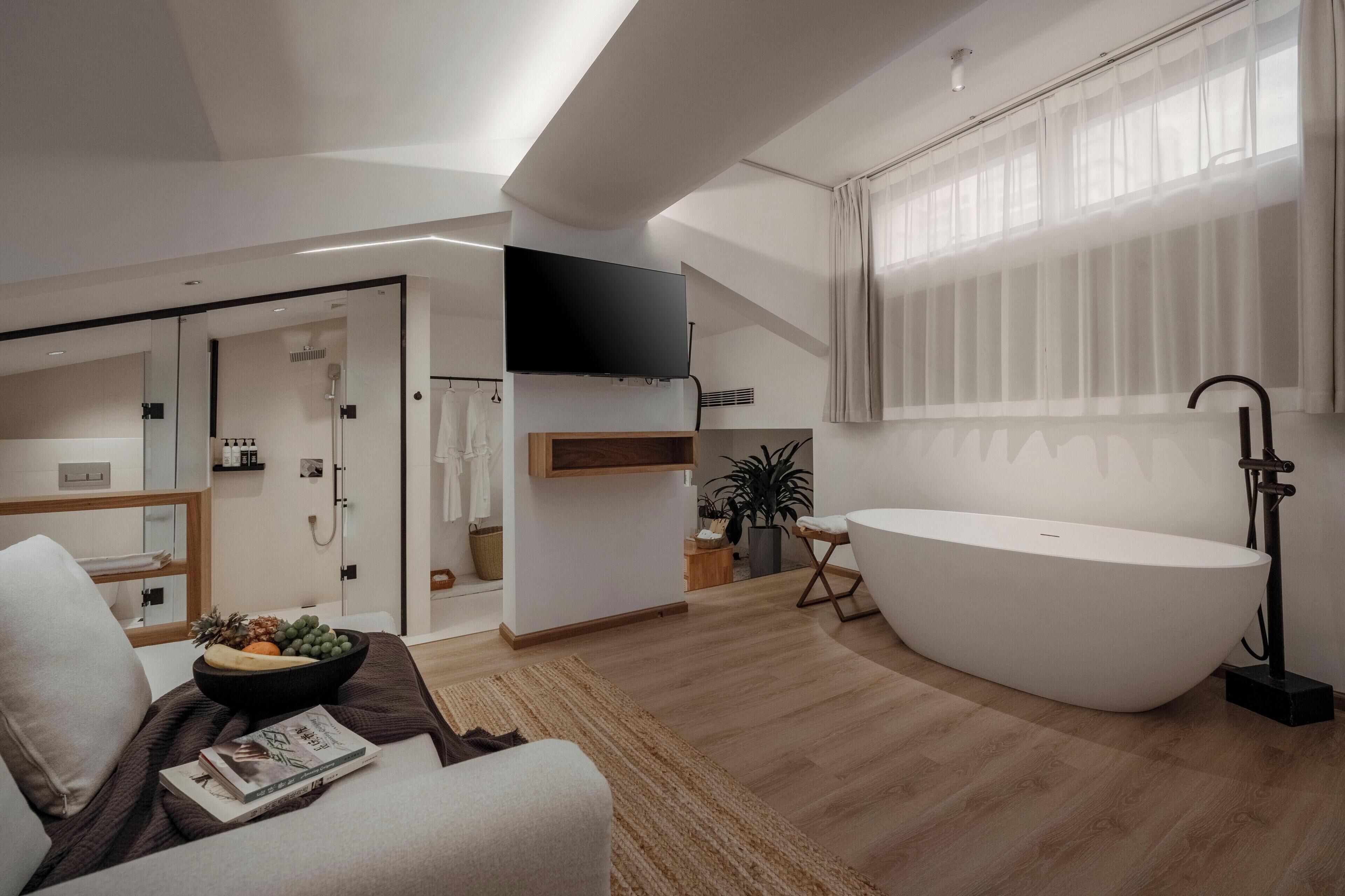 Une salle de bain moderne avec une baignoire sur pieds, une douche et des toilettes.