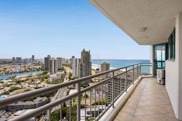 A balcony with a view of a coastal cityscape, including high-rise buildings and a marina. - Crown Towers Resort - Luxury Apartment (Surfers Paradise)