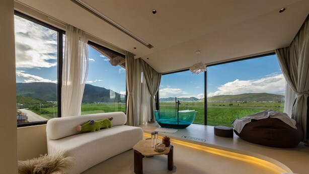 A modern living room with a sofa, a coffee table, a bean bag, and a glass bowl. - LOST VILLA-ff (Deqin)