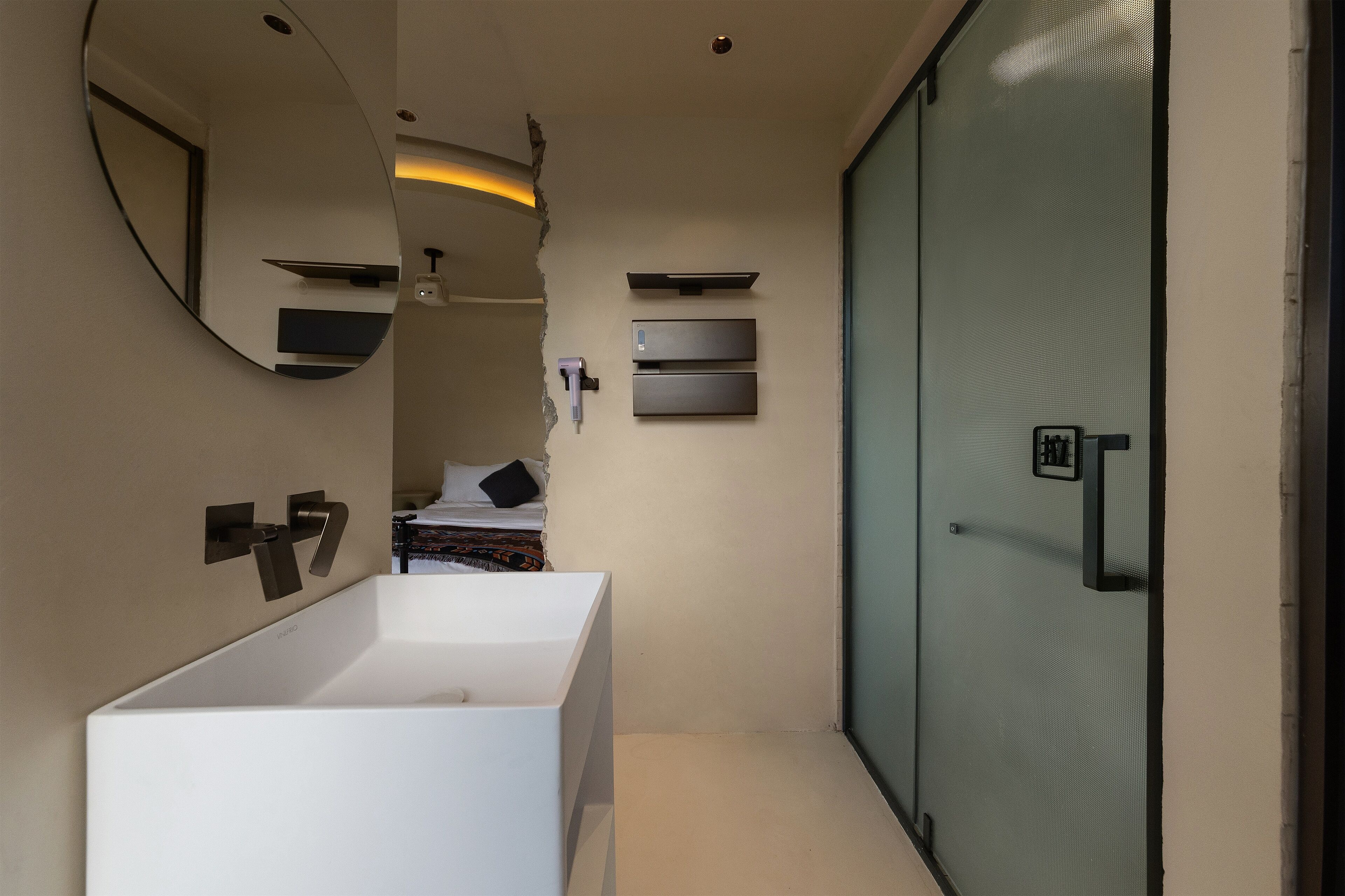 A modern bathroom with a large mirror, two sinks, and a sliding door.