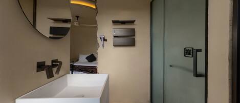 A modern bathroom with a large mirror, two sinks, and a sliding door.