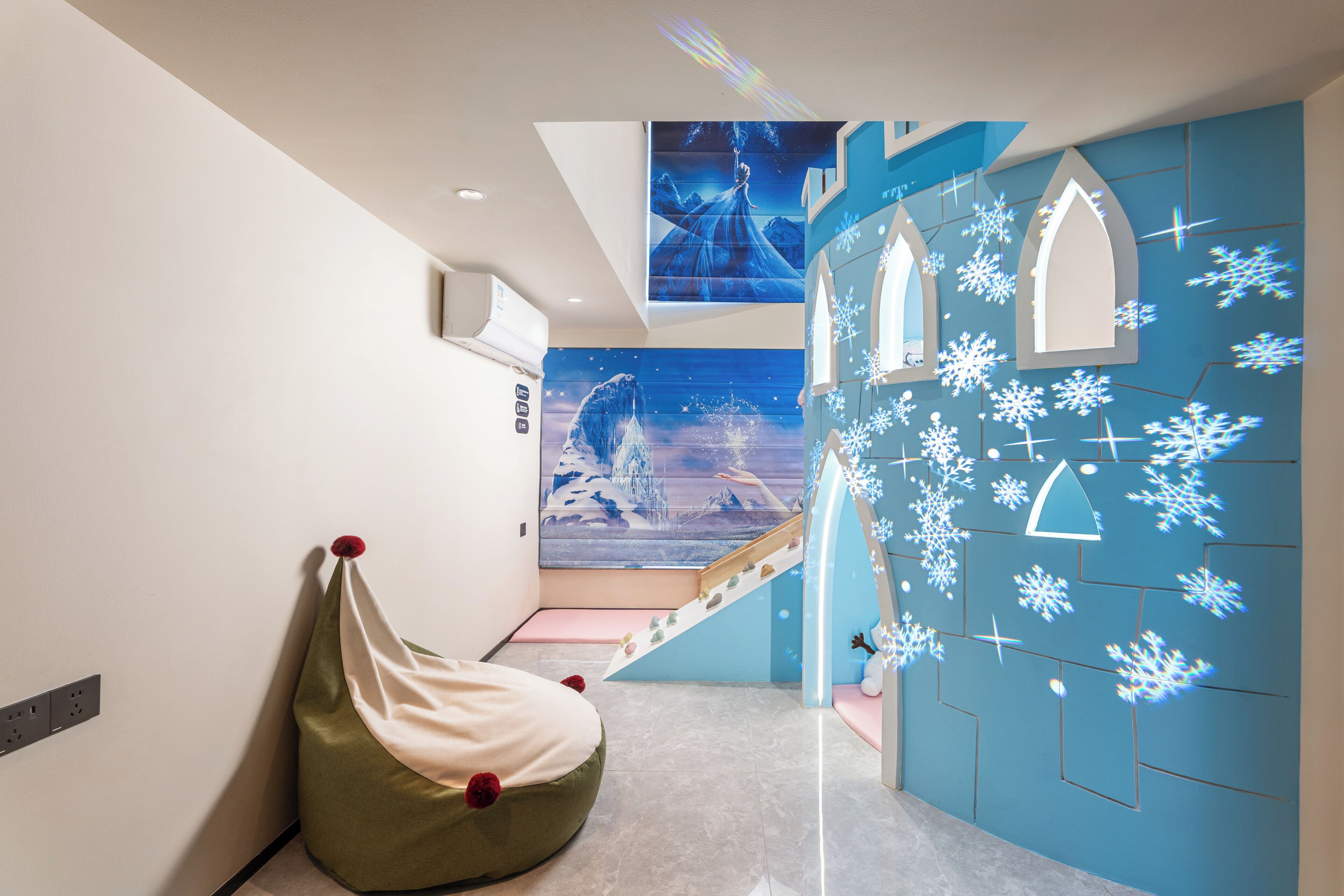 A modern interior with a bean bag chair, a staircase, and a wall with snowflake projections.