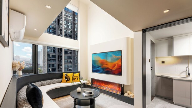 A modern living room with a curved sofa, a fireplace, and a large abstract painting. - GTOOO Hotel (Guangzhou)