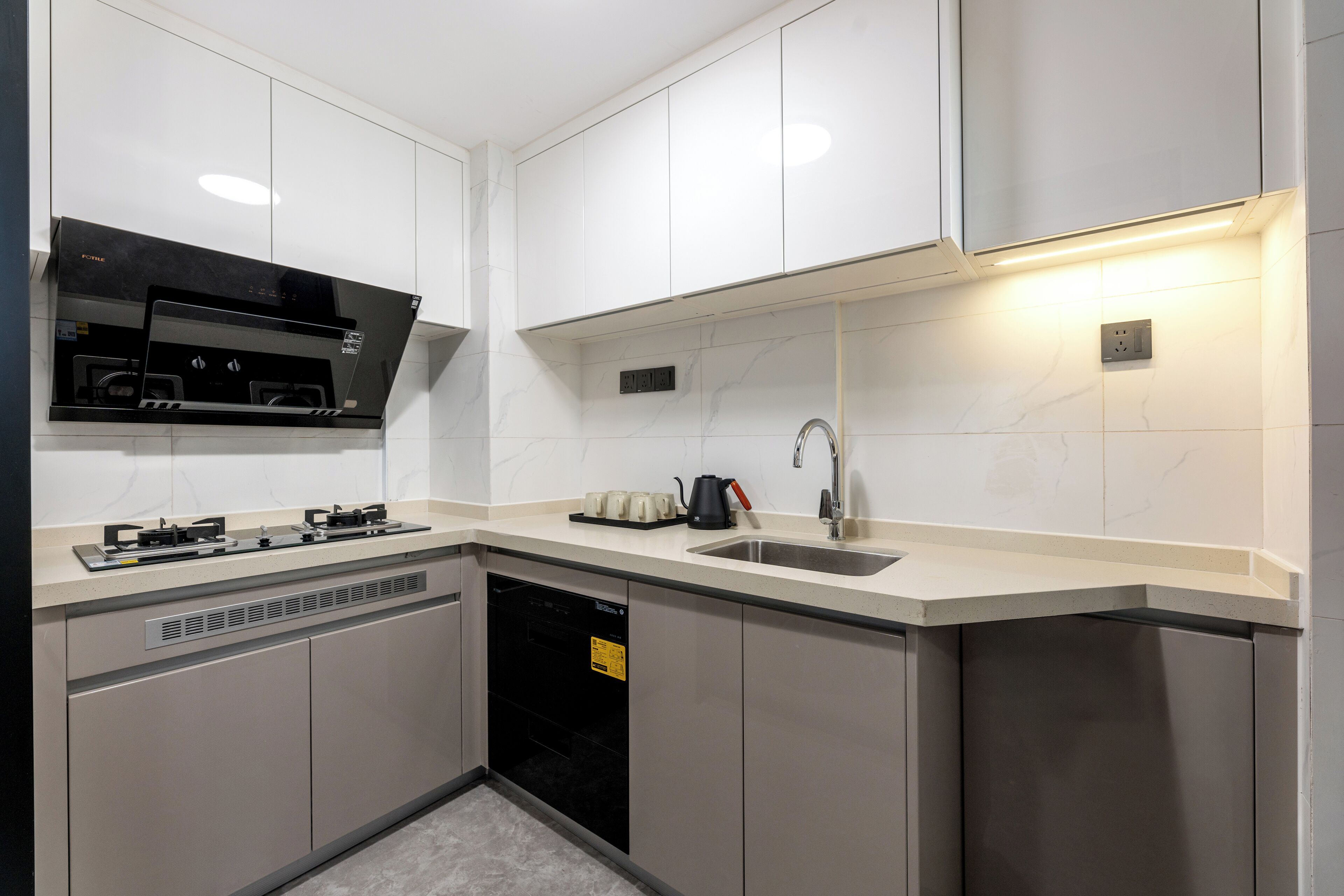 A modern kitchen with white cabinets, a black range hood, a stainless steel sink, and a dishwasher.