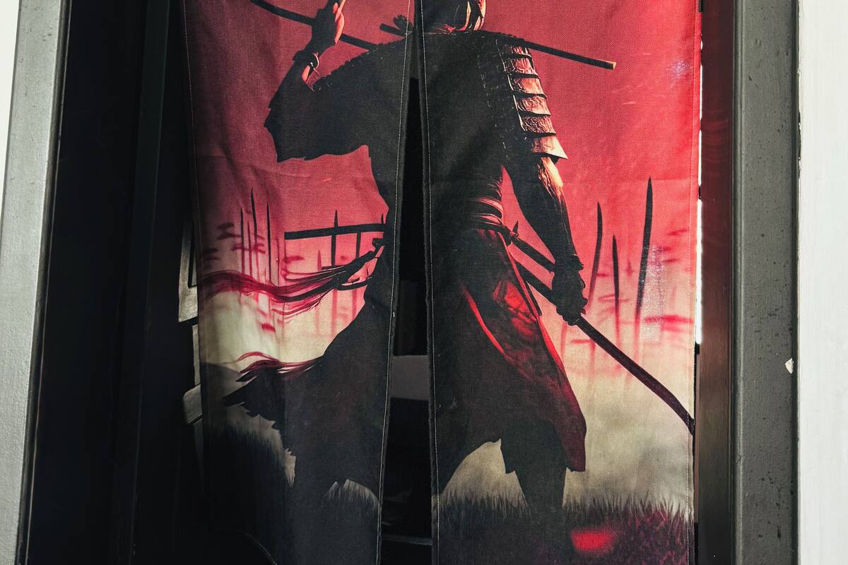 Une fenêtre avec un rideau à motifs rouges et noirs.