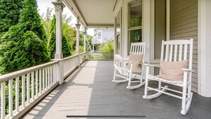 A covered porch with white railings and two rocking chairs. - Spacious 5-bedroom house with pool and two office rooms in charming Montclair (Montclair)