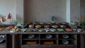 A buffet table with various dishes and a lamp.