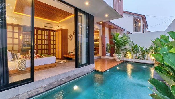 Une maison moderne dotée d’une piscine, d’un intérieur bien éclairé et offrant une vue sur la verdure environnante.