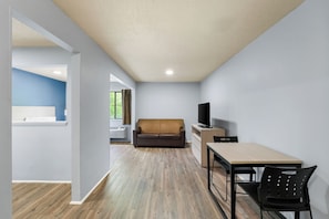 A modern living room with a sofa, TV, and dining area. - Hotel in Cary with WiFi, AC. (Cary)