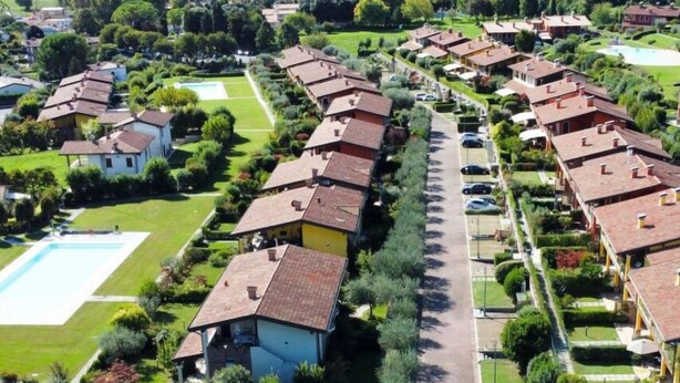 Zona residencial con casas, una piscina y una avenida central.
