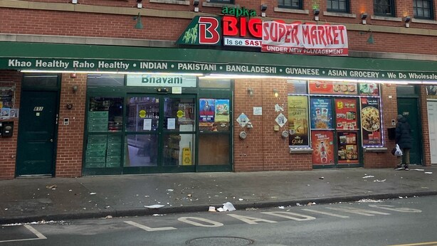 A brick building with multiple storefronts, including a grocery store named 'aapka BIG SUPER MARKET'. - Cjay Homes (Jersey City)