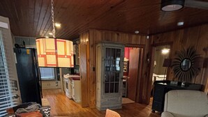 Une pièce chaleureuse avec un plafond en bois, une table à manger avec des chaises, un canapé et un tapis à motifs.