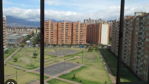 A residential area with high-rise apartment buildings, a central open space with a playground, and a road in the foreground. - Charming 2-bedroom apartment in enchanting Bogotá with WiFi (Bogotá)