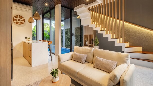 A modern living room with a sofa, a coffee table, and a staircase with illuminated steps. - Tropical Villa 8A - 8 Min Melasti Beach (Ungasan)