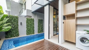 A modern outdoor area with a swimming pool, wooden deck, and built-in laundry facilities. - Tropical Villa 8A - 8 Min Melasti Beach (Ungasan)