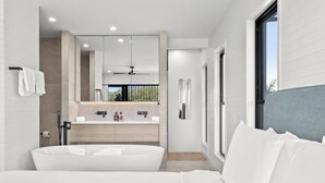 A modern bathroom with a freestanding bathtub, a large mirror, and a vanity with a countertop. - Salt Life Byron. Wifi, Parking & Pool in Paradise (Byron Bay)