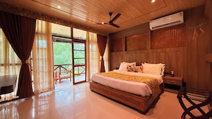 A spacious bedroom with a large bed, wooden headboard, and an air conditioning unit. - KAZIRANGA ECO VILLAGE RESORT (Kaliabar)