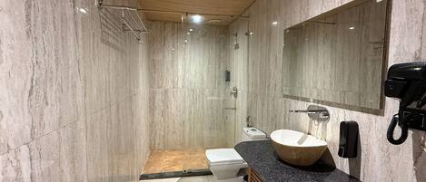A modern bathroom with a large mirror, a sink, and a toilet.