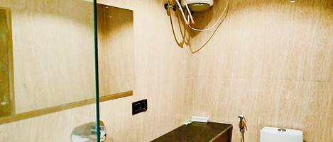 Une salle de bain moderne avec un plafond en bois, une cloison en verre, un lavabo avec un plan de toilette en marbre, des toilettes et un espace douche.