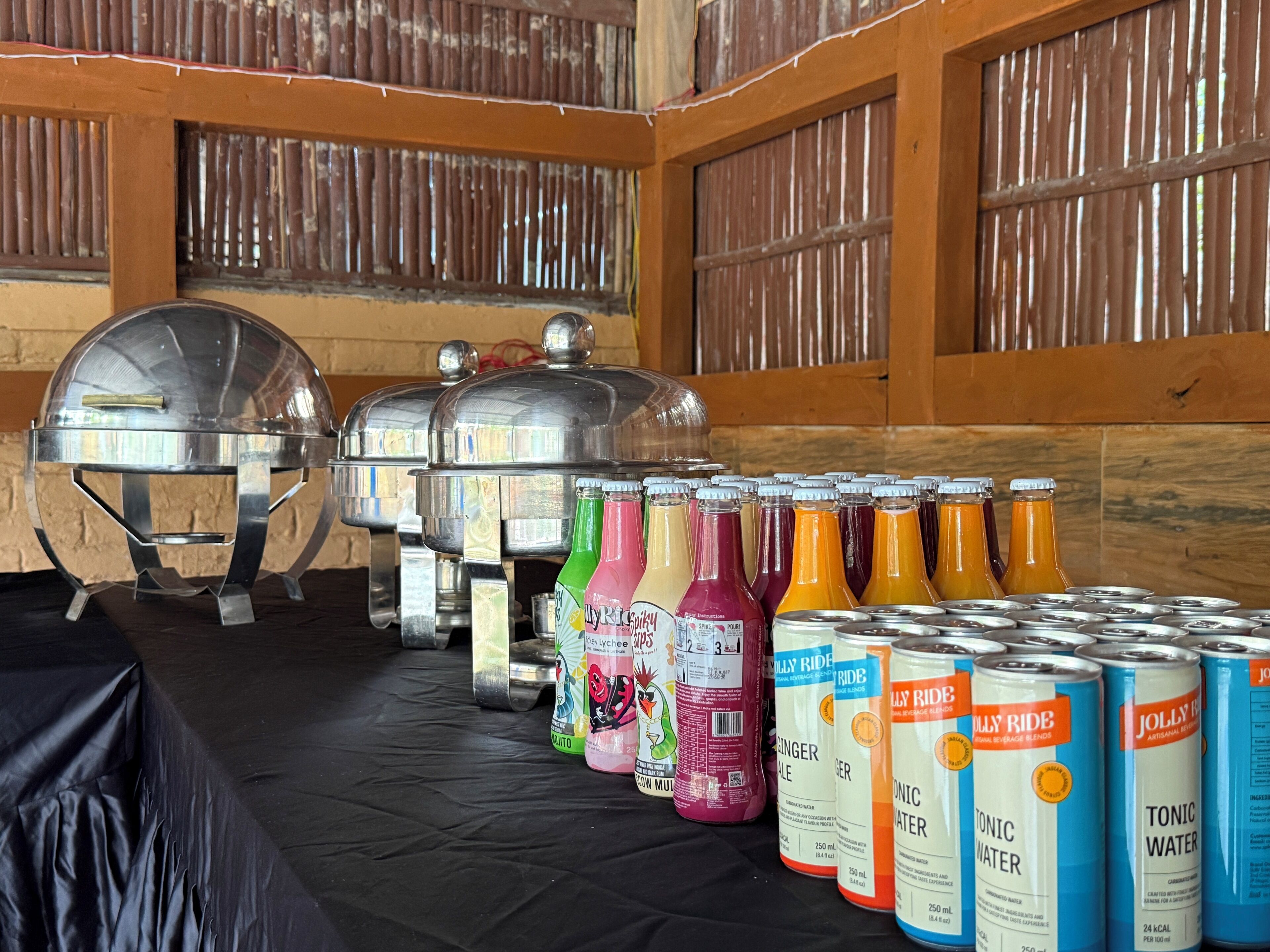 A buffet setup with various beverage options and covered food containers.