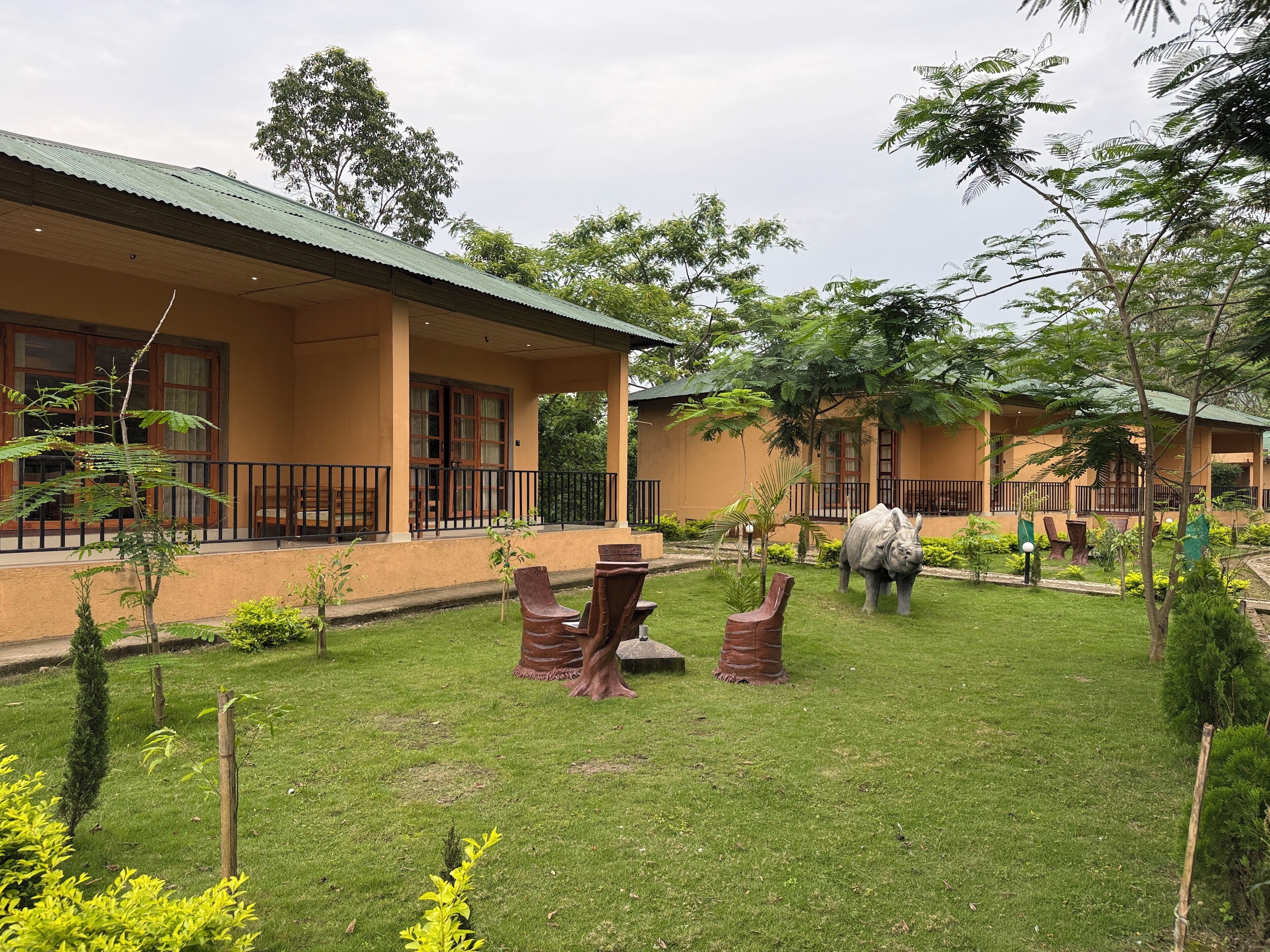 A courtyard with a grassy lawn, outdoor seating, and a statue of an elephant.