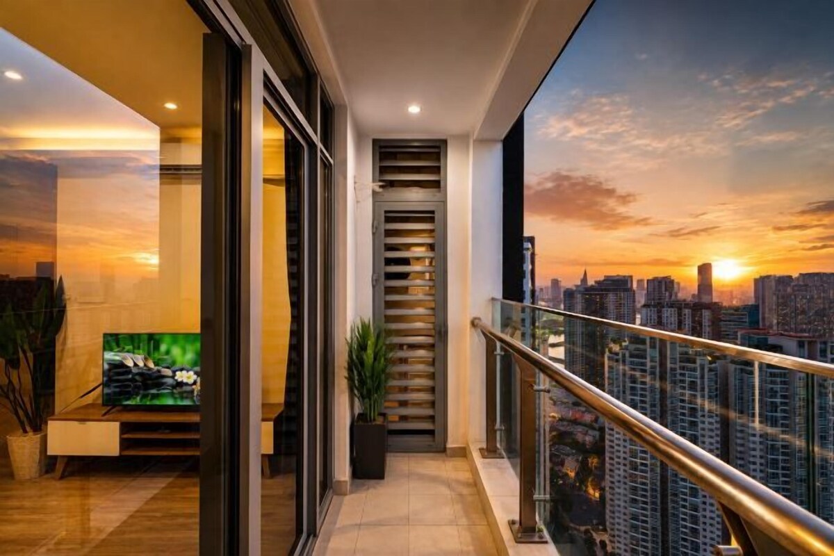 A balcony with a city view at sunset, a staircase, and a flat-screen TV on a stand.