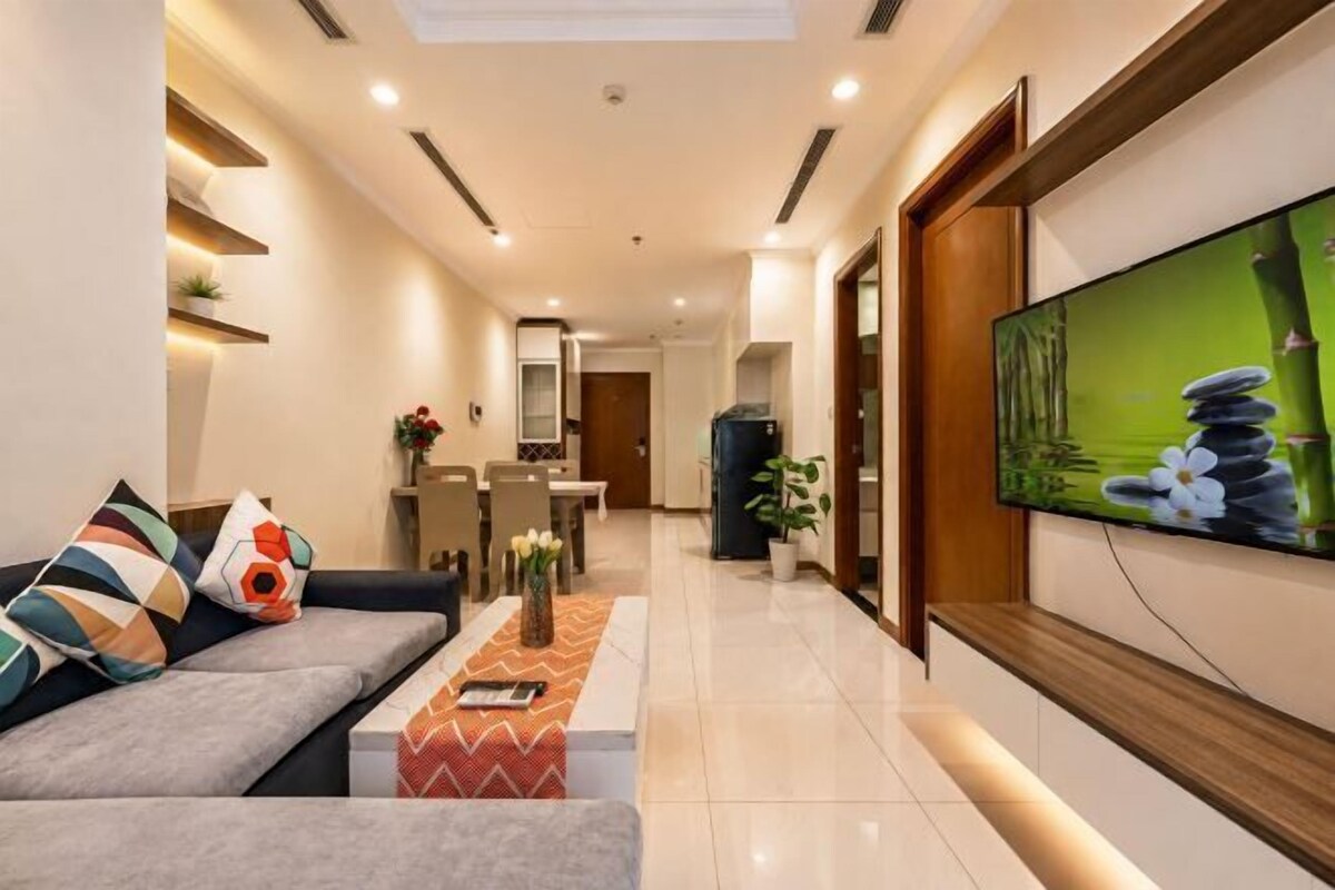 A modern living room with a sofa, a coffee table, and a flat-screen TV mounted on the wall.