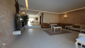 Un salón espacioso con un sofá, una mesa de centro y una zona de comedor a simple vista.