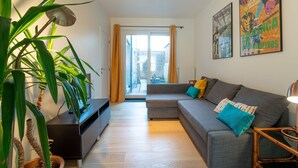 A modern living room with a grey sofa, a wooden coffee table, and a potted plant. - Sea of Tranquility with terrace by Interhome (Oostende)