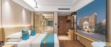 Habitación de hotel con una cama grande, un escritorio, un televisor y un cuadro de un edificio.