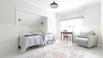 Una habitación con dos camas, un escritorio, una silla y un sofá.