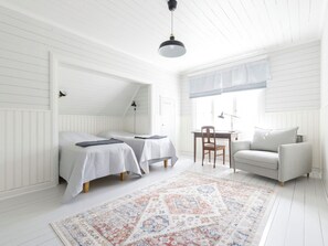 A room with two beds, a desk, a chair, and a sofa. - Kapteenin huvilat by Interhome (Parainen)