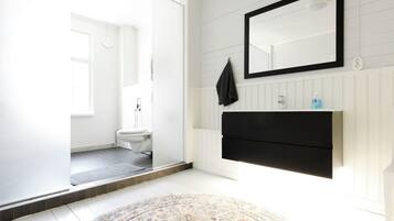 Un baño con inodoro, lavamanos y espejo.