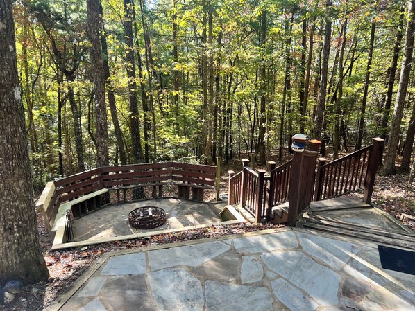 A stone staircase leading to a wooden deck surrounded by a forest.