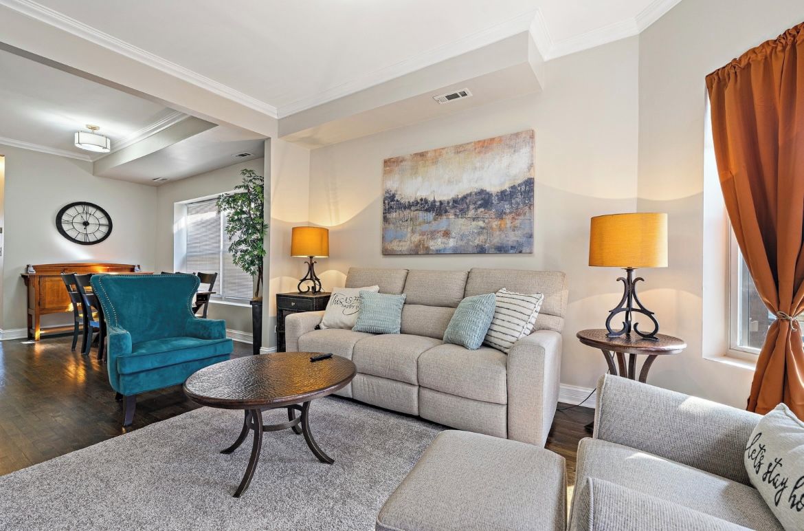 A living room with a sofa, armchairs, a coffee table, and lamps.