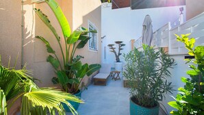 A small patio area with potted plants, a wooden table, and a chair. - CH Sierra de Gata La Marquesa Golf (Ciudad Quesada) (Ciudad Quesada)