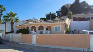 A building with a curved facade, arched windows, and a gated entrance. - CH Sierra de Gata La Marquesa Golf (Ciudad Quesada) (Ciudad Quesada)